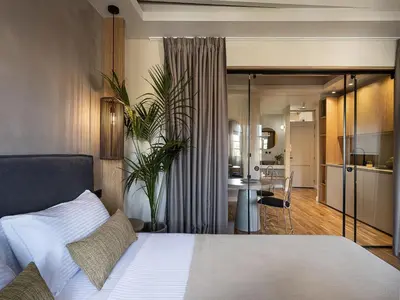 a bedroom with a white bed and a kitchen at Lithinon Luxury Suites with Free Parking in Chania Town
