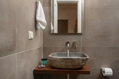 a bathroom with a stone sink and a mirror at Villa Tramonto - Falasarna in Falasarna