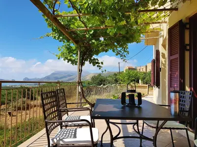 a table and chairs on a patio with a view at Villa Tramonto - Falasarna in Falasarna