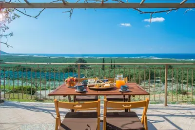 a table with food and fruit on it on a patio at Villa Tramonto - Falasarna in Falasarna