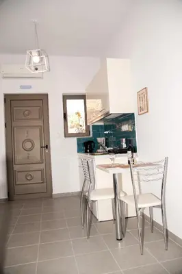 a kitchen with a table and chairs in a room at Efrilias Studios & Apartments in Kissamos