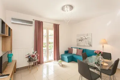 a living room with a blue couch and a table at Mary Suites Chania in Chania Town