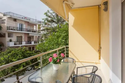 a balcony with a table with flowers on it at Mary Suites Chania in Chania Town