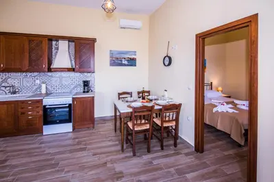 a kitchen and dining room with a table and a bed at Lardas Luxury Country House in Kissamos