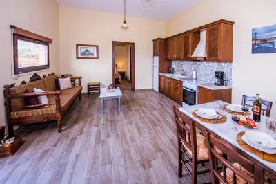 a kitchen and living room with a couch and a table at Lardas Luxury Country House in Kissamos