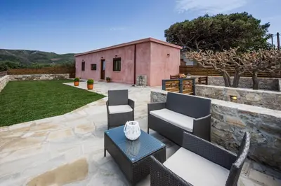 a patio with furniture and a stone wall at Lardas Luxury Country House in Kissamos