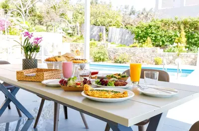 a table with food on it with a pool in the background at Villa Agrithea in Kissamos