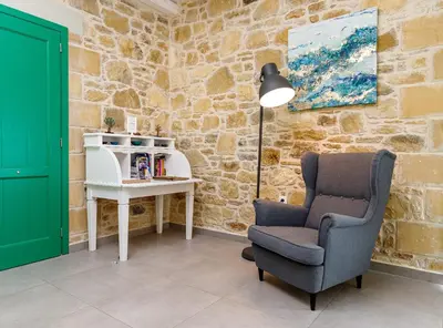 a room with a chair and a table with a lamp at Villa Agrithea in Kissamos