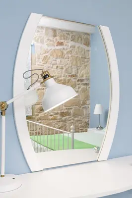 a mirror in a room with a lamp and a stone wall at Villa Agrithea in Kissamos
