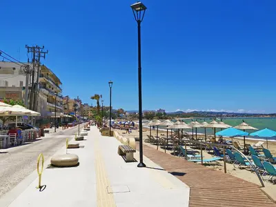 a street with chairs and umbrellas on a beach at Mare Civitas Apartments in Chania Town