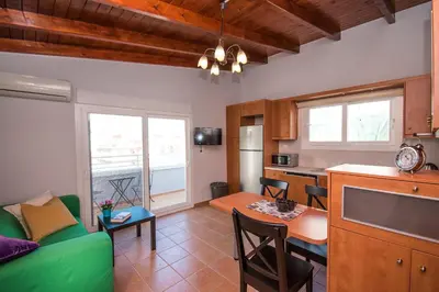 a kitchen and living room with a green couch and a table at Mare Civitas Apartments in Chania Town