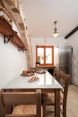 a kitchen with a table and a refrigerator at Casa Eleni in Chania Town