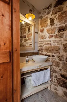a bathroom with a sink and a stone wall at Casa Eleni in Chania Town