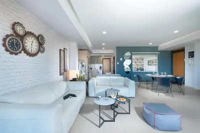 a living room with a white couch and a clock on the wall at Stefan's City Hub in Chania Town