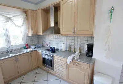 a kitchen with wooden cabinets and a sink at Villa-Jasmin in Kato Daratso