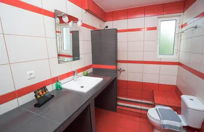 a red and white bathroom with a sink and a toilet at Naiades Luxury Apartments in Kalathas