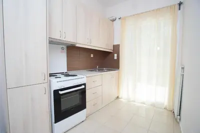 a kitchen with white cabinets and a stove top oven at Naiades Luxury Apartments in Kalathas