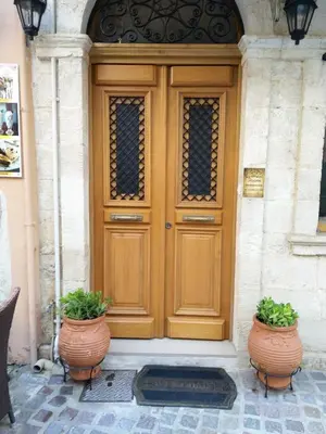 a wooden door with two plants in front of it at Santrivani Rooms in Chania Town