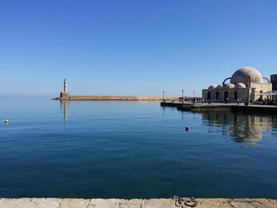 a mosque sitting next to a body of water at Santrivani Rooms in Chania Town
