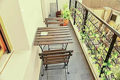 two benches sitting on a balcony with plants at Santrivani Rooms in Chania Town