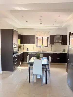 a kitchen with a table and white chairs in it at Villa Fanouris in Chania Town