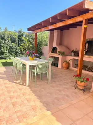 a patio with a table and chairs under a pergola at Villa Fanouris in Chania Town
