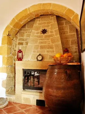 a stone fireplace with a large wooden barrel and a large wooden wine barrel at Fudulis Villa in Ravdhoúkha