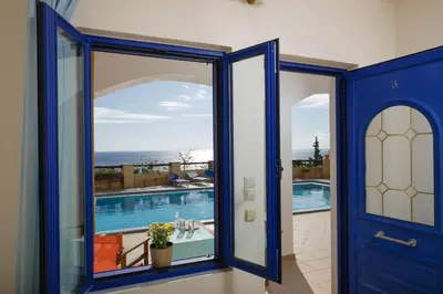 a house with a blue door and a swimming pool at Sfakian Horizon in Khóra Sfakíon