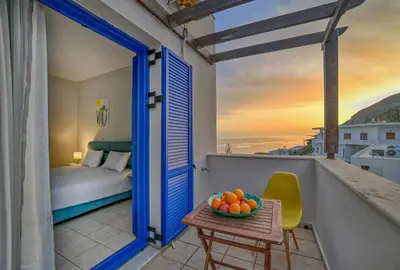 a room with a bed and a table with a bowl of fruit at Sfakian Horizon in Khóra Sfakíon