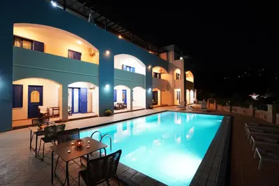 a swimming pool with tables and chairs next to a building at Sfakian Horizon in Khóra Sfakíon