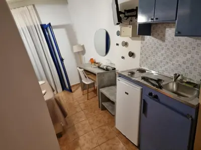 a small kitchen with a sink and a table at Loutro Holidays in Loutro