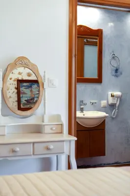 a bathroom with a sink and a mirror at Hamam Suites Portou in Chania Town