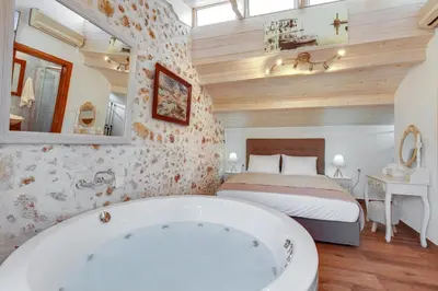 a bathroom with a bed and a tub in a room at Hamam Suites Portou in Chania Town