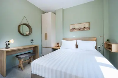 a bedroom with a bed and a desk and a mirror at Villa Levande in Sfinárion