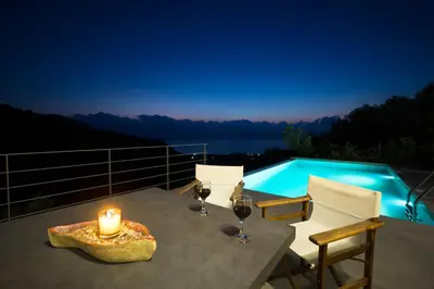 a table with two glasses of wine and a candle at Villa Levande in Sfinárion