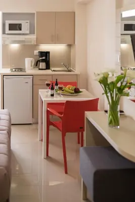 a kitchen with a red table and a red chair at Atrion Resort Hotel in Agia Marina Nea Kydonias