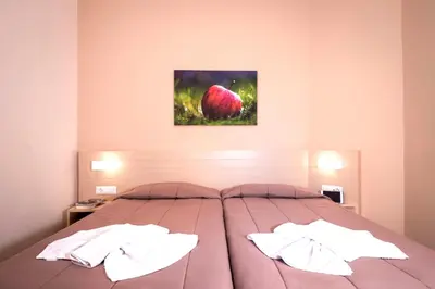 a bedroom with a large bed with two pillows at Atrion Resort Hotel in Agia Marina Nea Kydonias