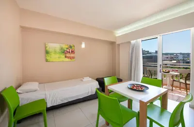 a hotel room with a bed and a table and chairs at Atrion Resort Hotel in Agia Marina Nea Kydonias