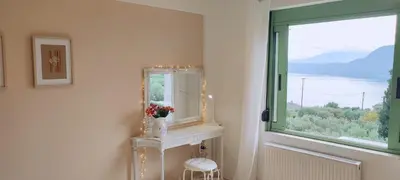 a bathroom with a mirror and a window with a view at The Garden of Zephyrus - West in Kounoupidhianá