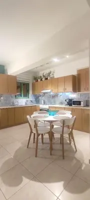 a kitchen with a table and chairs in it at The Garden of Zephyrus - West in Kounoupidhianá