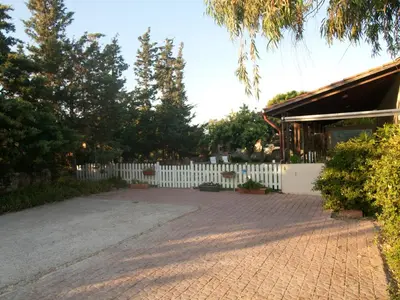 a house with a white fence and a brick driveway at The Garden of Zephyrus - West in Kounoupidhianá