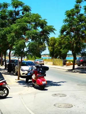 a red motorcycle parked on the side of a street at Beloni Apartments and Studios in Chania Town