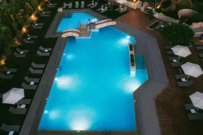 an overhead view of a large swimming pool with lounge chairs at Giannoulis – Santa Marina Beach Hotel in Agia Marina Nea Kydonias