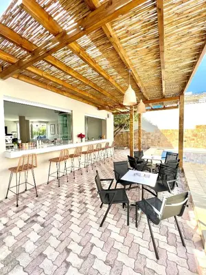 a patio with chairs and tables and a bar at Mediterranea Apartments in Kato Daratso