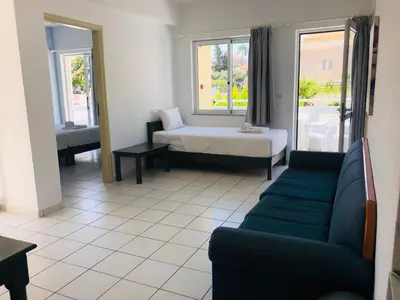 a living room with a couch and a bed at Mediterranea Apartments in Kato Daratso