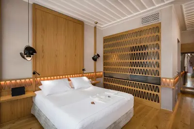 a bedroom with a white bed and a wooden wall at Scala de Faro in Chania Town