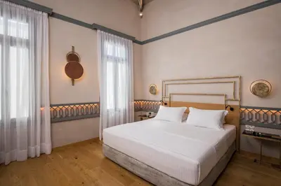 a bedroom with a white bed and a window at Scala de Faro in Chania Town