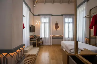 a bedroom with a bed and a desk in a room at Scala de Faro in Chania Town