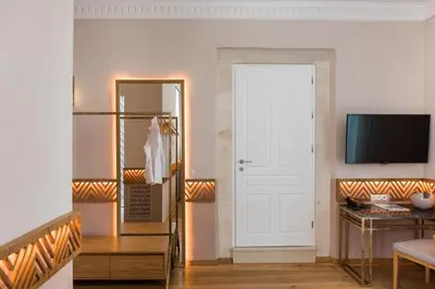 a living room with a white door and a mirror at Scala de Faro in Chania Town