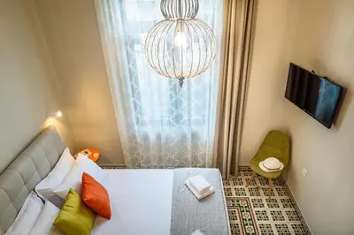 a bedroom with a bed and a chandelier at Mosaic in Chania Town
